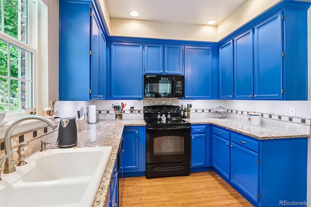 2992 W Long Dr Unit A, Littleton, CO 80120 - kitchen with black appliances, blue cabinets, recessed lighting, light stone counters, and decorative backsplash