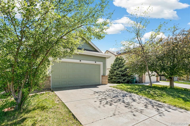 view of front facade featuring brick siding, driveway, a front lawn, and an attached garage