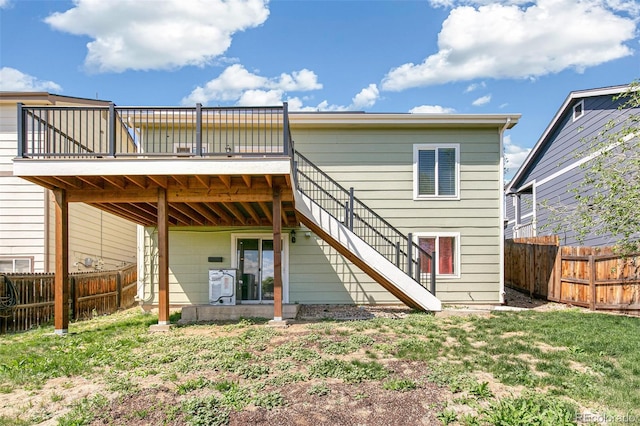 rear view of house featuring a deck, a fenced backyard, and stairs
