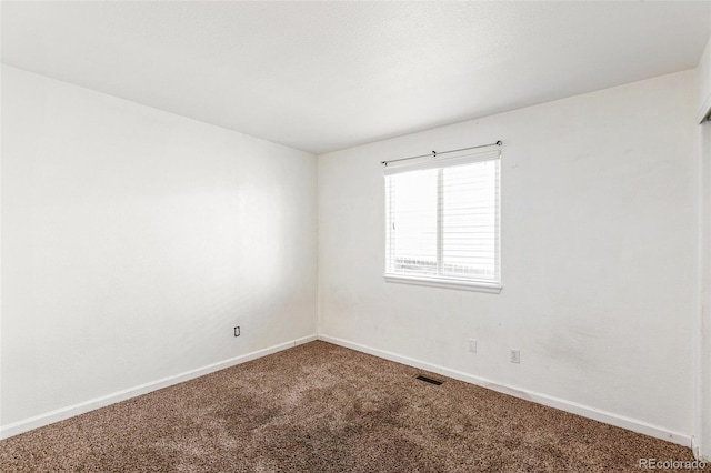 carpeted empty room featuring baseboards
