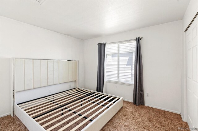 unfurnished bedroom featuring light carpet and baseboards