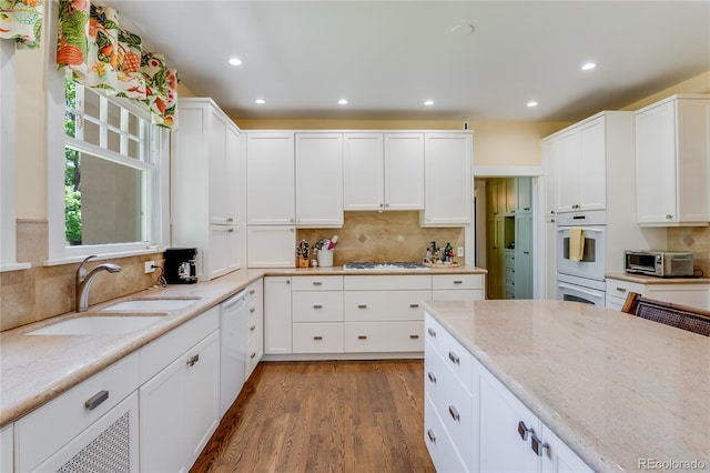 199 Lafayette St, Denver, CO 80218 - kitchen featuring white appliances, wood finished floors, decorative backsplash, white cabinetry, and recessed lighting