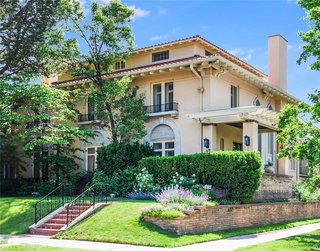 199 Lafayette St, Denver, CO 80218 - mediterranean / spanish-style house with stucco siding, a chimney, a front lawn, and a balcony