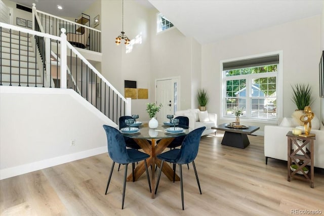 2089 Meadow Sweet Ln, Erie, CO 80516 - dining area featuring stairs, wood finished floors, a chandelier, and a towering ceiling