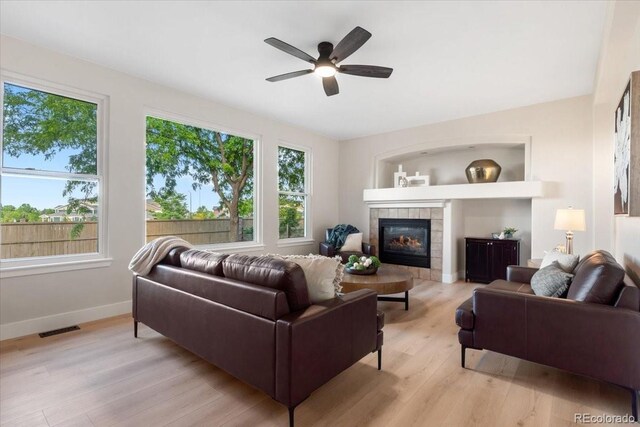 2089 Meadow Sweet Ln, Erie, CO 80516 - living room featuring light wood-style floors, ceiling fan, and a fireplace