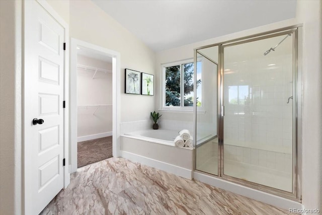 2089 Meadow Sweet Ln, Erie, CO 80516 - bathroom with lofted ceiling, a stall shower, a garden tub, marble look tiles, and a spacious closet