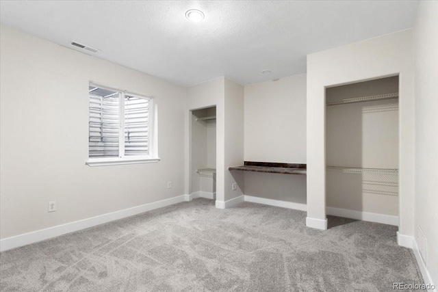 2089 Meadow Sweet Ln, Erie, CO 80516 - unfurnished bedroom featuring carpet, multiple closets, and a textured ceiling