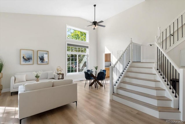 2089 Meadow Sweet Ln, Erie, CO 80516 - living room featuring stairs, healthy amount of natural light, wood finished floors, a ceiling fan, and high vaulted ceiling