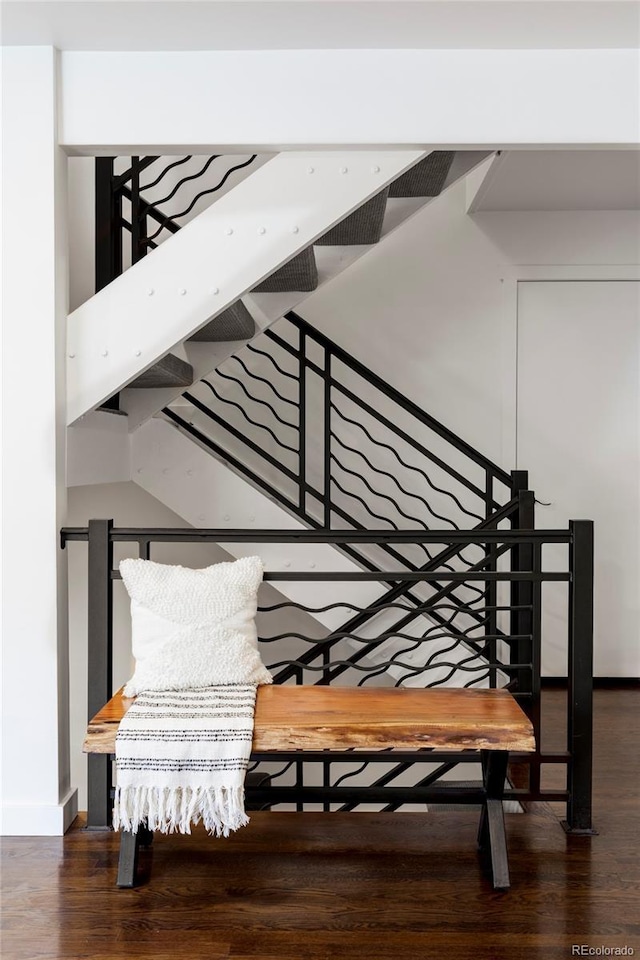 staircase with baseboards and wood finished floors