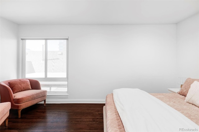 bedroom with dark wood-type flooring and baseboards