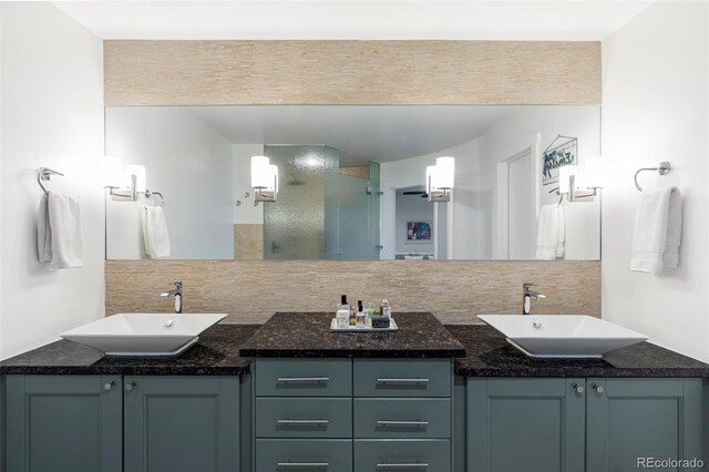 full bathroom featuring double vanity, backsplash, and a sink