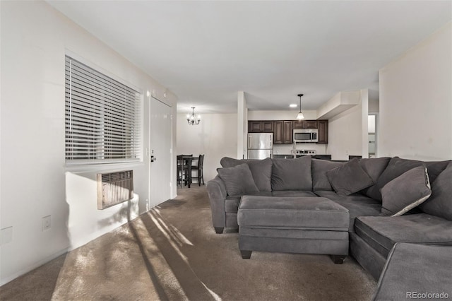 living room featuring dark carpet, heating unit, and a notable chandelier