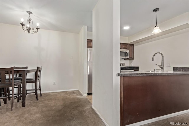 kitchen with decorative light fixtures, sink, an inviting chandelier, and stainless steel appliances