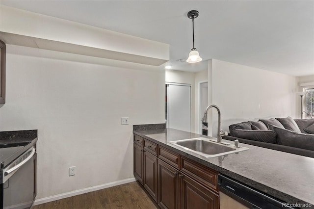 kitchen featuring pendant lighting, appliances with stainless steel finishes, dark brown cabinetry, dark hardwood / wood-style flooring, and sink