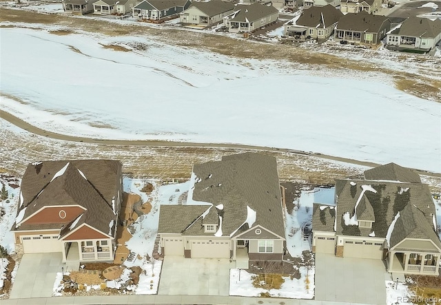 snowy aerial view with a residential view