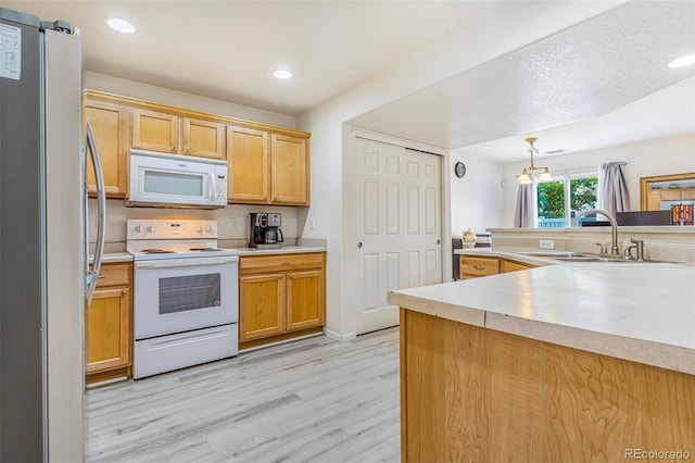 5895 Biscay St Unit D, Denver, CO 80249 - kitchen featuring white appliances, a sink, light wood-type flooring, light countertops, and recessed lighting