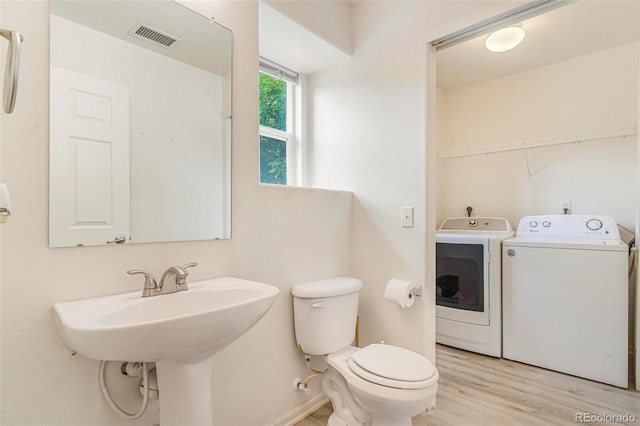 5895 Biscay St Unit D, Denver, CO 80249 - bathroom featuring separate washer and dryer, toilet, and wood finished floors