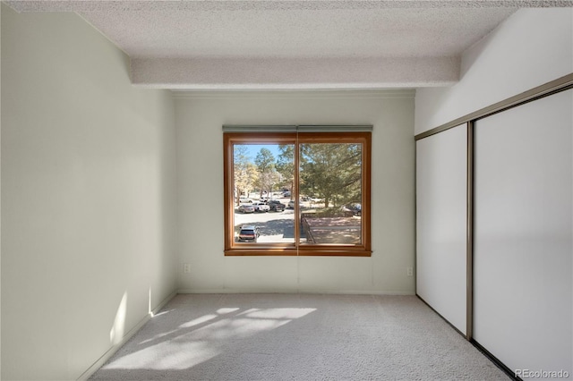 empty room with carpet floors and a textured ceiling
