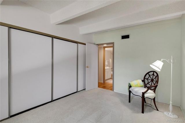 living area with beam ceiling, carpet floors, and baseboards