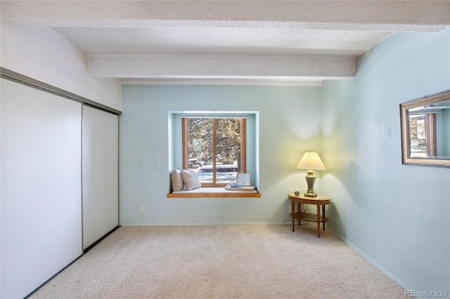 bedroom with carpet flooring, a textured ceiling, a closet, and beamed ceiling