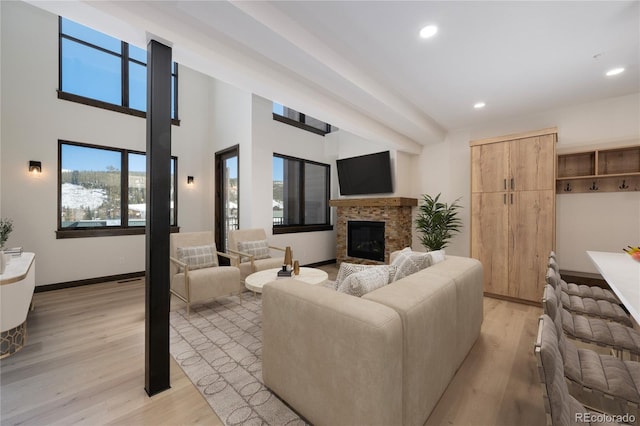 living room featuring a stone fireplace and light hardwood / wood-style flooring