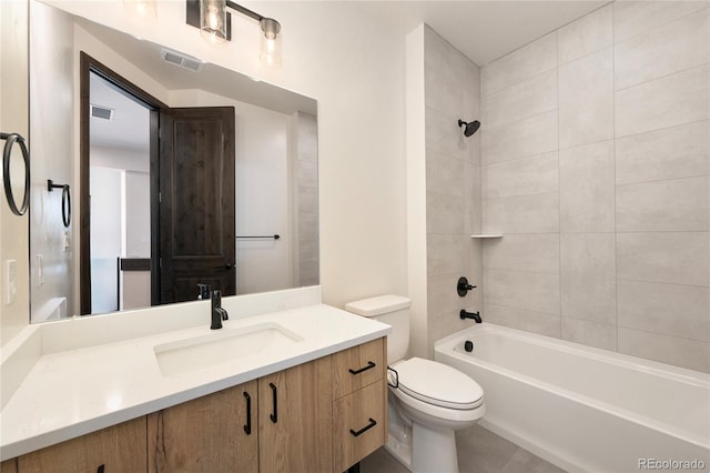 full bathroom featuring vanity, tiled shower / bath combo, and toilet