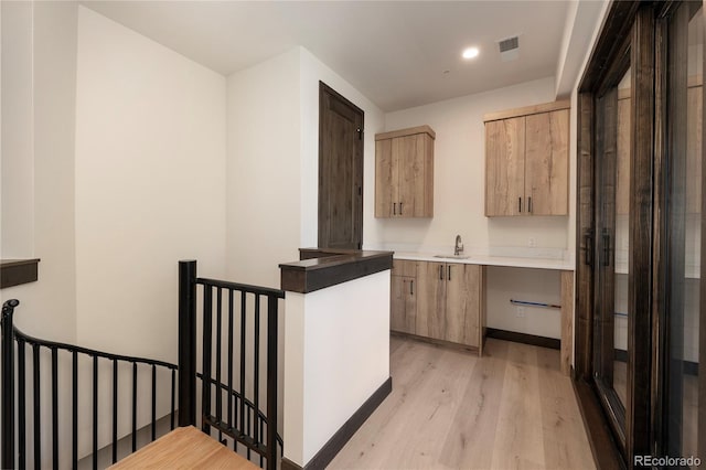 kitchen with sink, light hardwood / wood-style flooring, and light brown cabinets