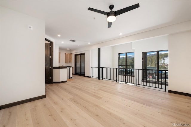 unfurnished living room with ceiling fan and light wood-type flooring