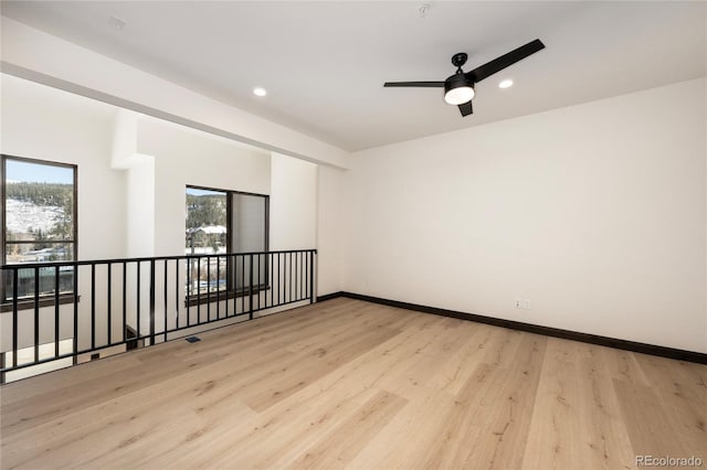 spare room with ceiling fan and light wood-type flooring