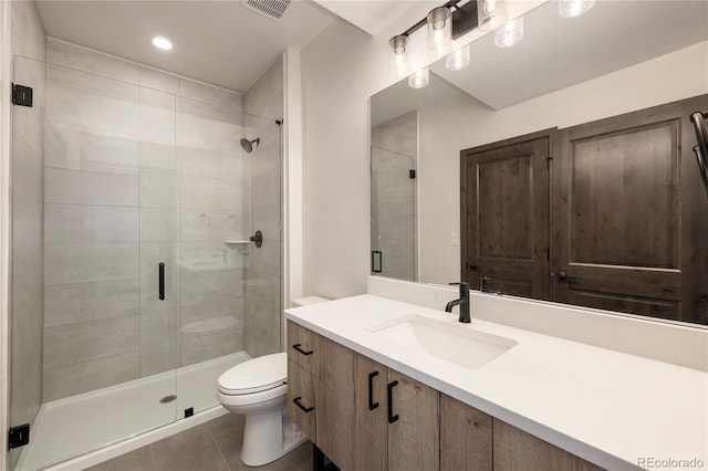 bathroom featuring vanity, toilet, a shower with door, and tile patterned flooring