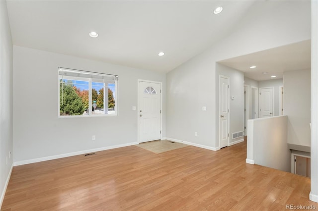 entryway with vaulted ceiling and light hardwood / wood-style flooring