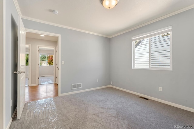 empty room featuring light carpet and crown molding