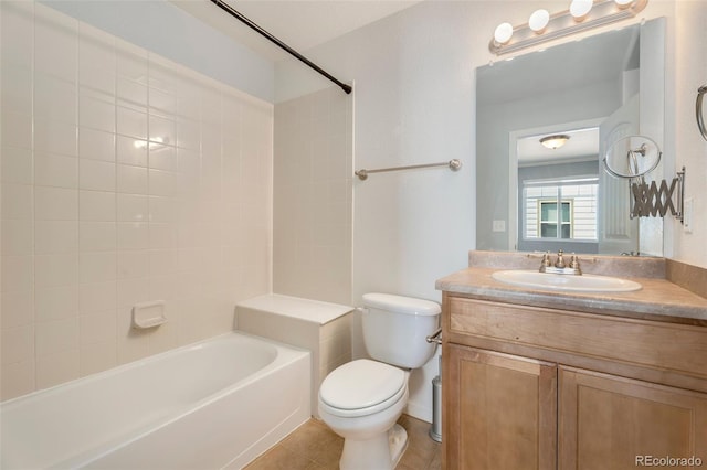 full bathroom with tiled shower / bath, tile patterned floors, vanity, and toilet