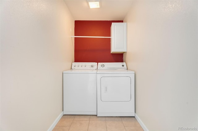 laundry room featuring independent washer and dryer, cabinets, and light tile patterned floors