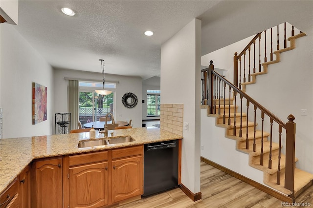 2972 W Long Dr Unit C, Littleton, CO 80120 - kitchen with black dishwasher, light wood finished floors, a textured ceiling, light stone counters, and recessed lighting