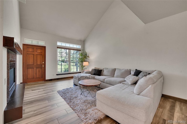 2972 W Long Dr Unit C, Littleton, CO 80120 - living area featuring high vaulted ceiling, light wood-type flooring, and a glass covered fireplace