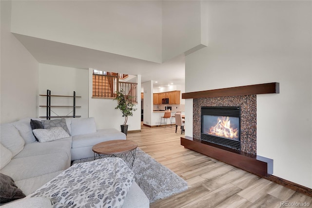 2972 W Long Dr Unit C, Littleton, CO 80120 - living room featuring light wood-type flooring, a tile fireplace, and a towering ceiling