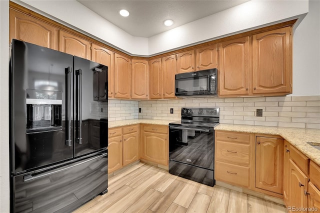2972 W Long Dr Unit C, Littleton, CO 80120 - kitchen featuring black appliances, light stone countertops, light wood-style flooring, tasteful backsplash, and recessed lighting