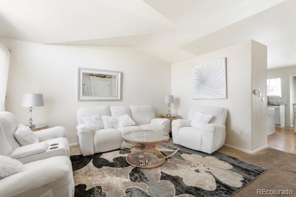 carpeted living room featuring vaulted ceiling