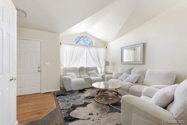 living room with hardwood / wood-style flooring and vaulted ceiling