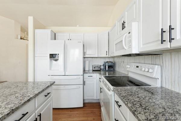 kitchen with white cabinetry, light stone counters, white appliances, and dark hardwood / wood-style floors