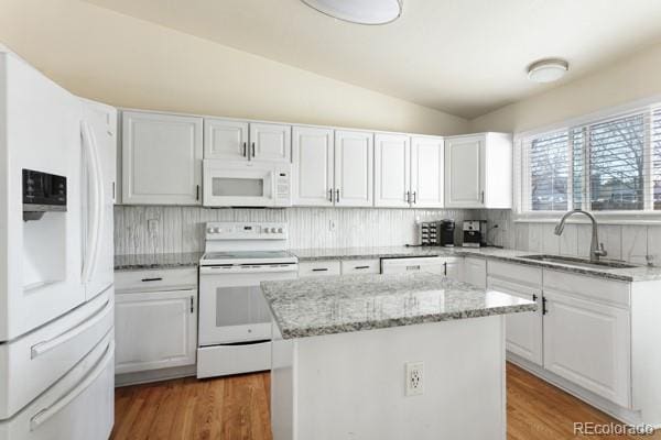 kitchen with white cabinetry, white appliances, a center island, and sink