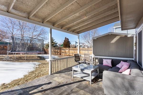 wooden terrace featuring outdoor lounge area, a patio area, and a trampoline