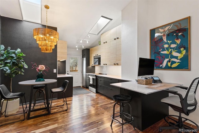 interior space with stainless steel microwave, dark wood finished floors, light countertops, range with electric stovetop, and a kitchen breakfast bar