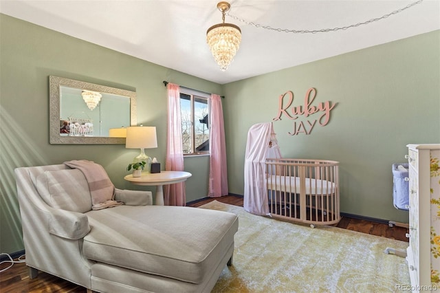 bedroom featuring a chandelier and a nursery area