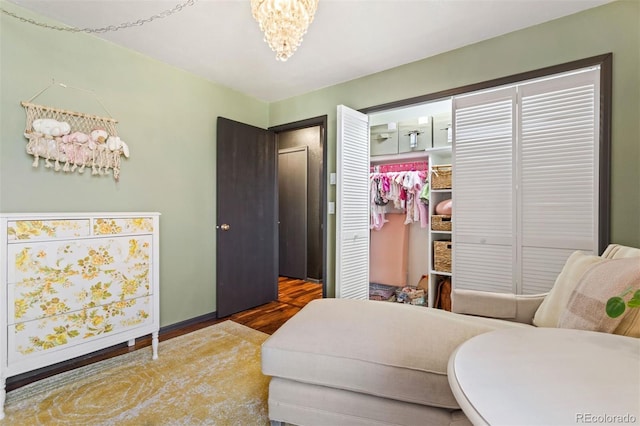 bedroom featuring wood finished floors and a chandelier