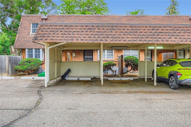 1200 S Monaco St Parkway Unit 31, Denver, CO 80224 - view of front of home with a shingled roof, brick siding, covered parking, and mansard roof