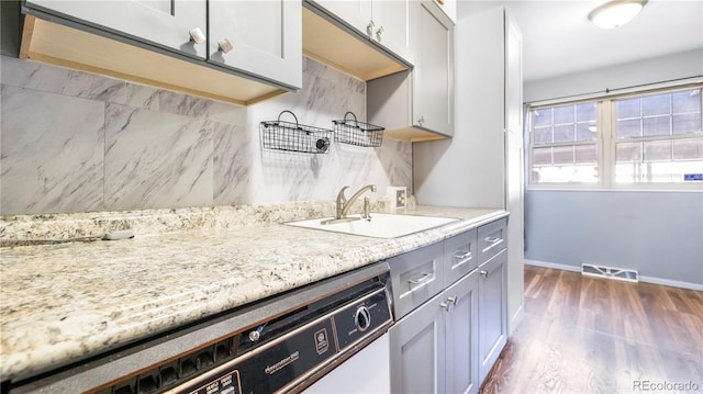 1200 S Monaco St Parkway Unit 31, Denver, CO 80224 - kitchen with tasteful backsplash, dark wood finished floors, dishwashing machine, light stone countertops, and gray cabinets