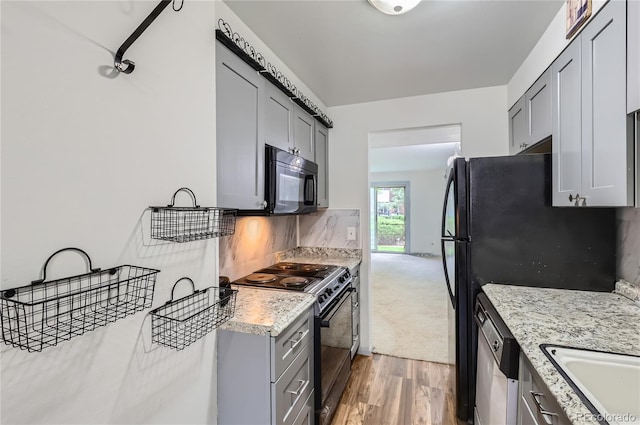 1200 S Monaco St Parkway Unit 31, Denver, CO 80224 - kitchen with black appliances, gray cabinetry, light wood finished floors, backsplash, and light stone countertops