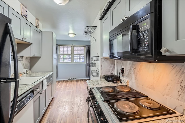 1200 S Monaco St Parkway Unit 31, Denver, CO 80224 - kitchen with black appliances, backsplash, and light wood-style flooring